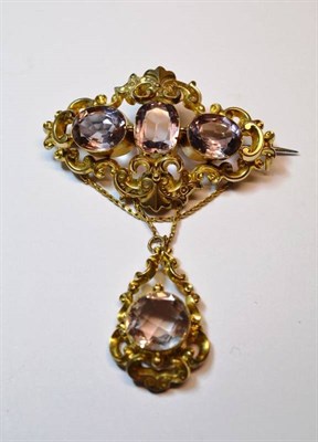 Lot 629 - A Victorian Brooch, three mixed cut amethysts within a scrolling frame, with swags suspended to...