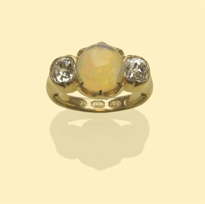 Lot 640 - An 18 Carat Gold Opal and Diamond Three Stone Ring, the oval cabochon opal flanked by an old...