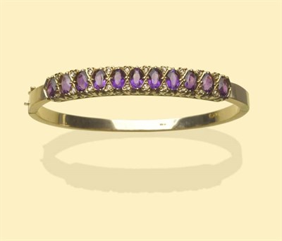 Lot 646 - A 9 Carat Gold Amethyst and Diamond Bangle, oval cut amethysts with pairs of tiny rose cut diamonds