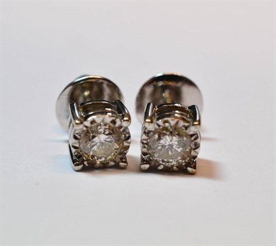 Lot 660 - A Pair of 18 Carat White Gold Diamond Solitaire Earrings, the round brilliant cut diamonds in white