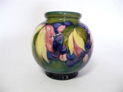 Lot 1125 - A William Moorcroft Leaf and Grape Pattern Vase, on a blue/green wash ground, impressed factory...