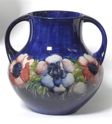 Lot 1142 - A William Moorcroft Anemone Pattern Twin-Handled Vase, on a blue ground, impressed factory...