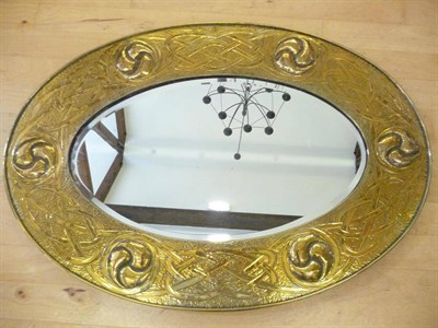 Lot 1217 - Scottish School: An Arts & Crafts Brass Mirror, circa 1900, the oval frame decorated with...