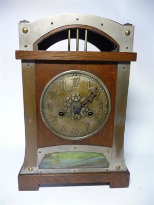 Lot 1219 - A Jugendstil Oak and Metal Mounted Mantel Clock, arched top, over an embossed brass 14.5cm...