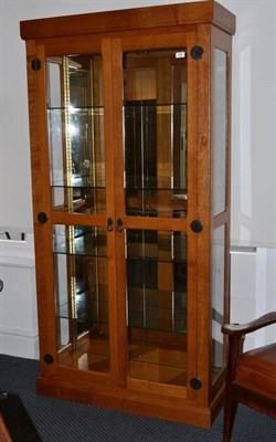 Lot 1268 - An Old Mill Furniture Glazed Oak Illuminated Display Cabinet, with four panel mirror back and...