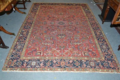 Lot 1391 - Heriz Carpet Persian Azerbaijan The terracotta field of stylised angular vines enclosed by...