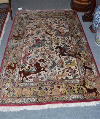 Lot 1424 - Fine Ghom Silk Rug The ivory field depicting hunting scenes and flowering plants enclosed by...