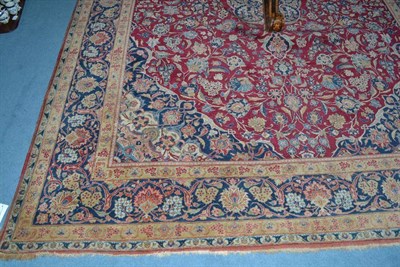 Lot 1425 - Kashan Carpet  Central Persia The raspberry field of scrolling vines and palmettes around an indigo