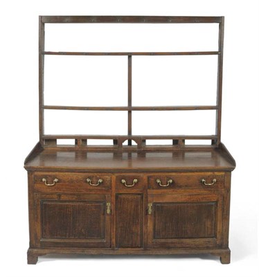 Lot 1558 - A George III Oak Enclosed Dresser and Rack, late 18th century, the fixed shelves with iron cup...