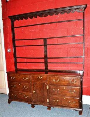 Lot 1561 - An 18th Century Oak Enclosed Dresser and Rack, the dentil wavy shaped apron above three fixed...