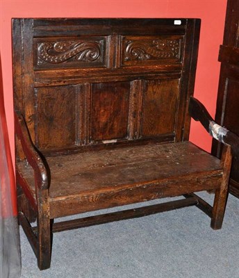 Lot 1564 - A Joined Oak Settle, 18th century in part, with carved and fielded back support above downswept...