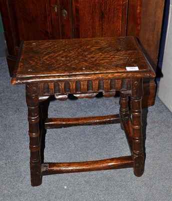 Lot 1565 - An Oak Joint Stool, the moulded top above a fluted frieze and shaped moulding, raised on ring...