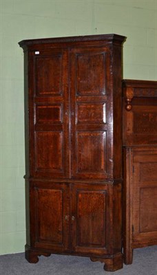 Lot 1570 - A George III Oak and Mahogany Crossbanded Free-Standing Corner Cupboard, late 18th century, the...