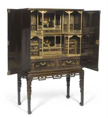 Lot 1634 - An Early 19th Century Chinese Black Lacquer Cabinet on Stand, richly painted overall in gold...