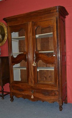 Lot 1639 - A French Walnut Armoire, of large proportions, the moulded pediment above brass grille doors...