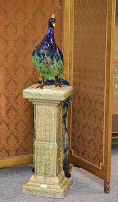 Lot 90 - A Majolica Style Figure of a Peacock, the standing bird with naturalistic foliage, on a square...