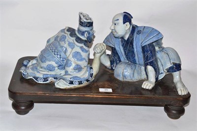 Lot 95 - An Arita Porcelain Figure Group, in 17th century style, as a man and an oni arm wrestling, both...