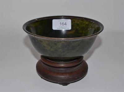 Lot 164 - A Chinese Spinach Jade Bowl, Qing Dynasty, the slightly everted rim with white metal mount,...