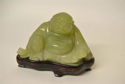 Lot 167 - A Chinese Jade Figure of Buddha, Qing Dynasty, the seated figure with flowing robes holding a...