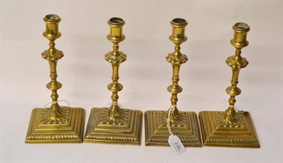 Lot 239 - A Set of Four Brass Candlesticks, 20th Century, with waisted sconces, knopped baluster stems,...