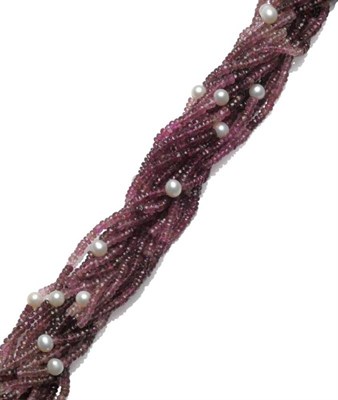 Lot 384 - A Pink Tourmaline and Freshwater Cultured Pearl Torsade, the shaded faceted beads of pink...