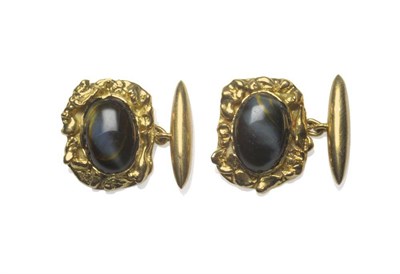 Lot 418 - A Pair of Cufflinks, a central dark cat's-eye cabochon stone, within a yellow asymmetric frame,...