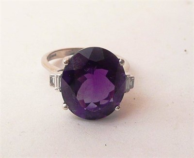 Lot 432 - An 18 Carat White Gold Amethyst and Diamond Ring, an oval cut amethyst between a pair of...