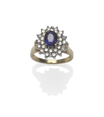 Lot 440 - An 18 Carat Gold Sapphire and Diamond Cluster Ring, the oval mixed cut sapphire within a double...