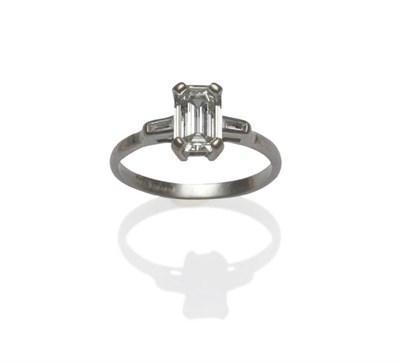 Lot 451 - A Platinum Diamond Solitaire Ring, a baguette cut diamond in a four claw setting to collet set...