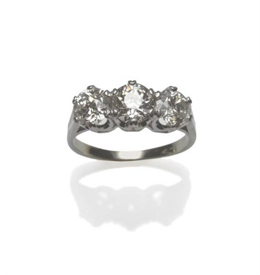 Lot 456 - A Diamond Three Stone Ring, the graduated old cut diamonds in white claw settings to a shaped...