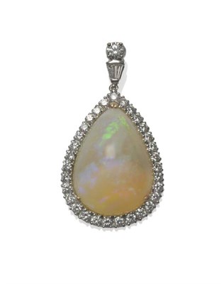 Lot 471 - An 18 Carat White Gold Opal and Diamond Pendant, a triangular domed cabochon opal within a...