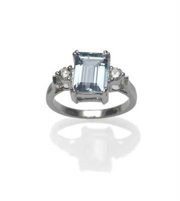 Lot 486 - An Aquamarine and Diamond Three Stone Ring, the emerald-cut aquamarine between two round...