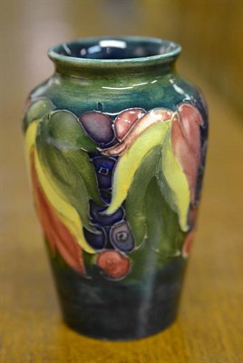 Lot 943 - A William Moorcroft Leaf and Grape Pattern Vase, on a green/blue ground, impressed factory mark and