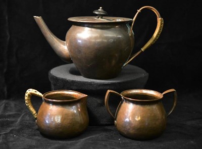 Lot 1037 - A Keswick School of Industrial Arts Copper Three Piece Teaset, hammered effect, the teapot and milk