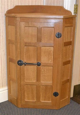 Lot 1062 - A Robert  "Mouseman " Thompson Panelled Oak Hanging Corner Cupboard, the interior fitted with three