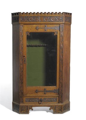 Lot 1102 - An Arts & Crafts Oak and Pine Corner Glazed Gun Cabinet, with castellated top over a...