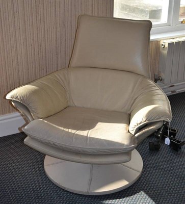 Lot 1124 - A 1970's Padded Swivel Easy Chair, covered in cream leather, on a covered circular base, labelled O