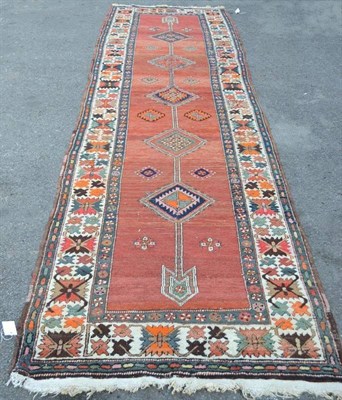 Lot 1248 - North West Persian Runner The abrashed madder field with a column of stepped linked medallions...