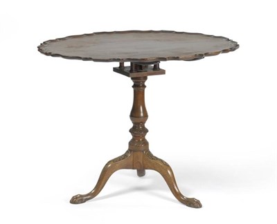 Lot 1353 - A George II Style Mahogany Tripod Table, the moulded pie-crust edge with carved shells, raised on a