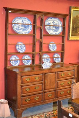 Lot 1393 - A Joined Oak Enclosed Dresser and Associated Rack, the bold cornice above open shelves, the...