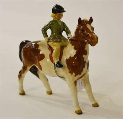 Lot 1131 - Beswick Girl on Skewbald Pony, model No. 1499, brown and white pony, rider in green jacket...