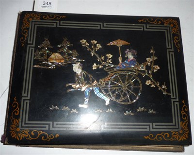 Lot 348 - A Japanese Black Lacquered Postcard Album, the front board inlaid in mother of pearl with a...