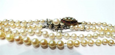 Lot 5 - Two graduated cultured pearl necklaces, one with a 9 carat gold garnet and split pearl clasp...