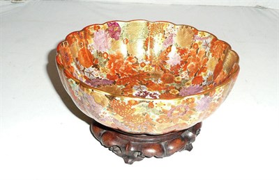 Lot 117 - A Japanese Satsuma earthenware 'chrysanthemum' bowl, late Meiji period (1868 - 1912) on wooden...