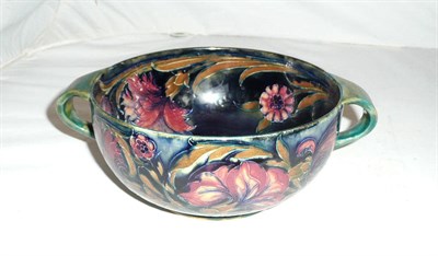 Lot 147 - A Moorcroft pottery twin handled bowl decorated in the Spanish design on a blue ground (a.f.)