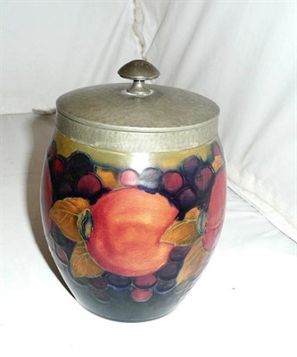 Lot 148 - A Moorcroft pottery tobacco jar decorated in the pomegranate design on a blue ground, complete with