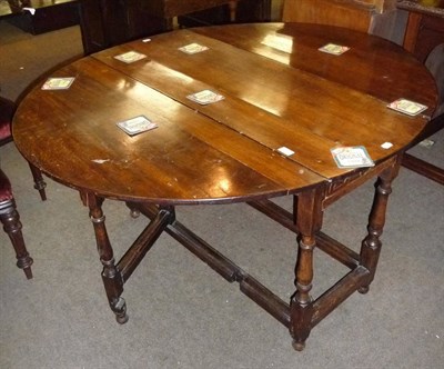 Lot 570 - An oak gateleg dining table