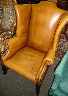 Lot 622 - Leather upholstered wing armchair