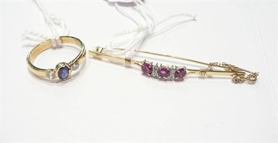 Lot 12 - An 18ct gold sapphire and diamond three stone ring and a ruby and diamond bar brooch