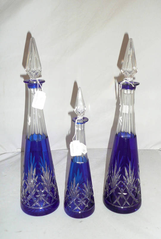 Lot 50 - A pair of blue flash glass decanters with stoppers and a small example